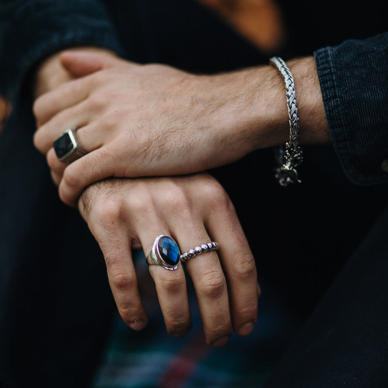 Model draagt zilveren armband met draak en twee zilveren ringen waarvan één met Labradoriet