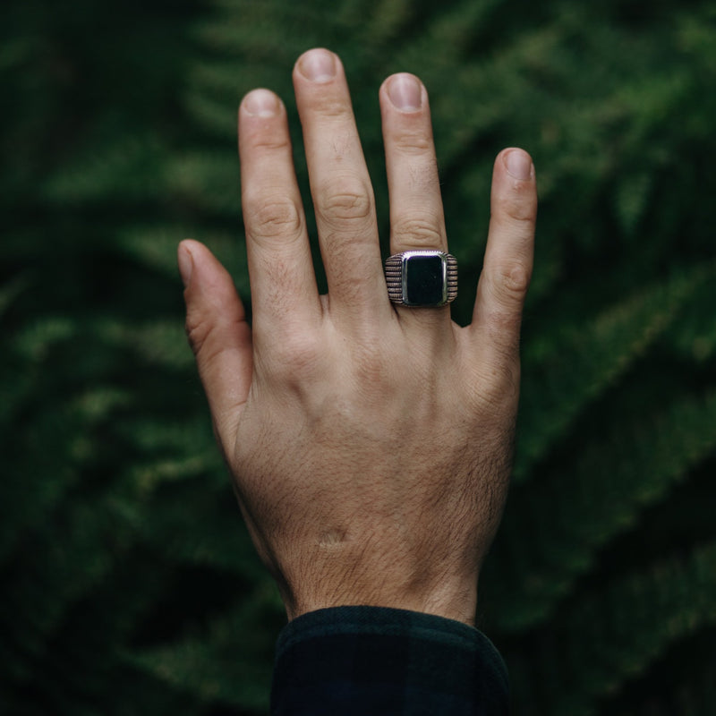 Model steekt hand omhoog met een zilveren ring met Mosagaat